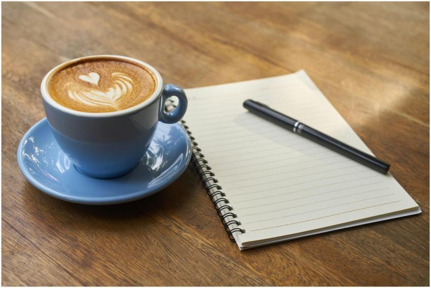 A calming scene of a latte with art in a blue cup