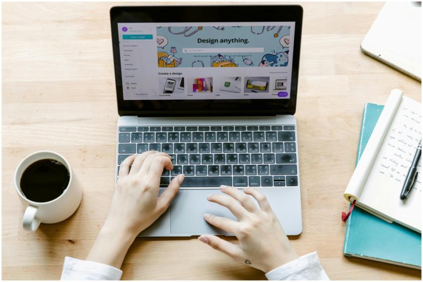 Overhead shot of hands typing on a laptop with cof