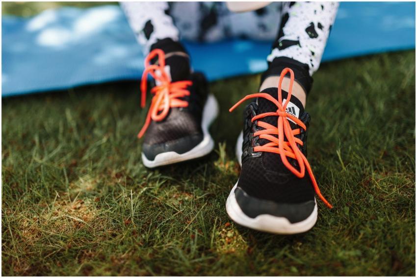 Close-up of sneakers with red laces on grassy fiel