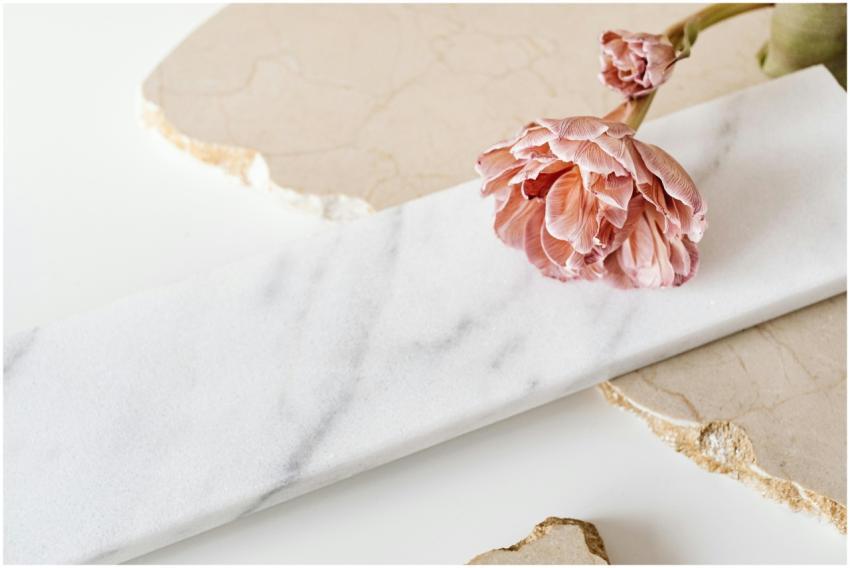 A pink flower gracefully placed on a white marble