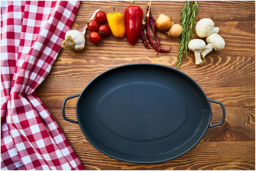 Empty cast iron pan with fresh ingredients on a wo