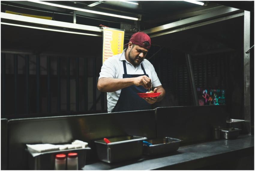 Taco vendor preparing fresh Mexican tacos at a nig