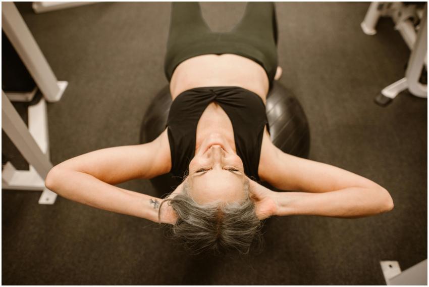 Senior woman performing exercise on stability ball