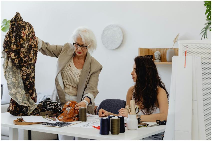 Two women in a fashion studio discussing fabrics a
