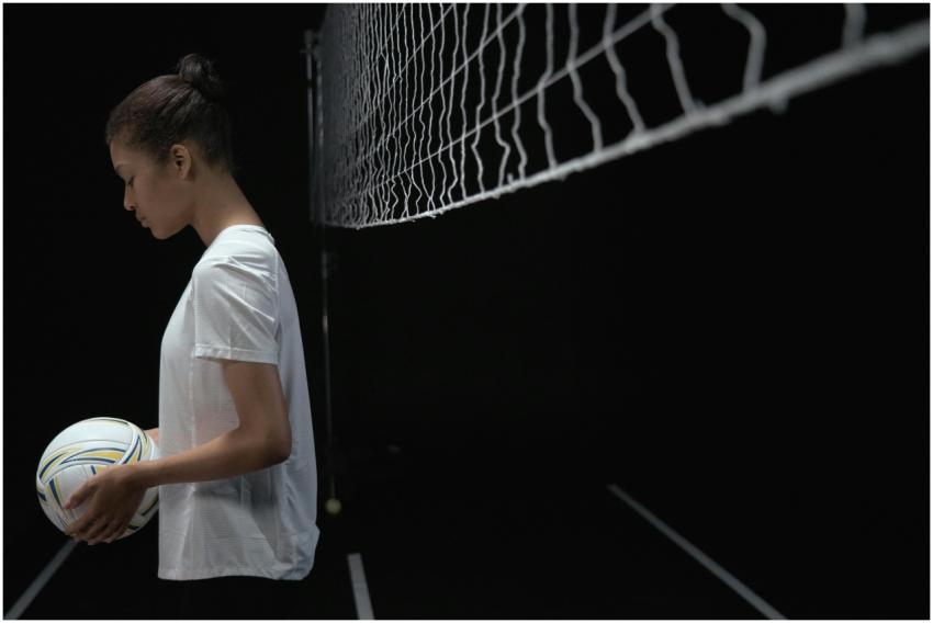 Focused female volleyball player holding a ball in