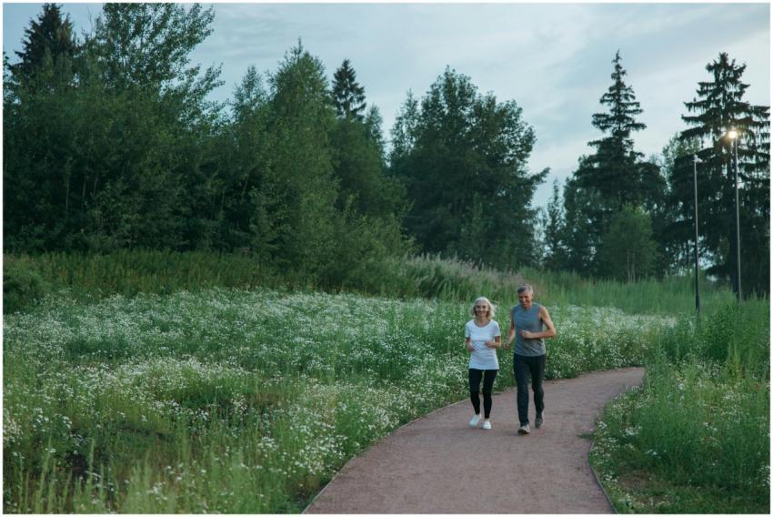 Senior couple jogging on a scenic park path surrou