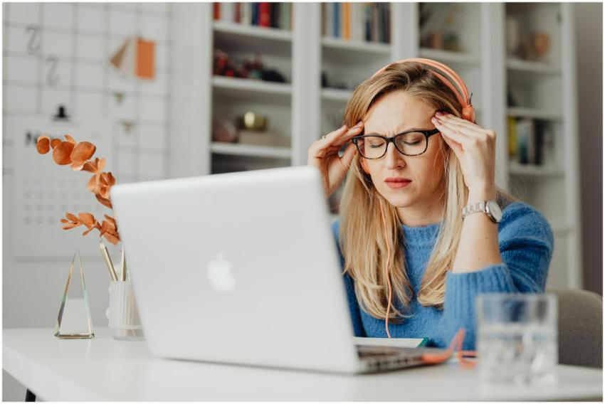 A woman experiencing stress while working on a lap