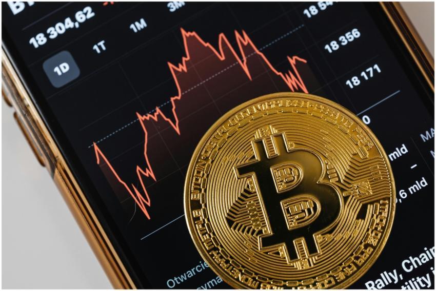 A close-up of a gold Bitcoin coin placed on a smar