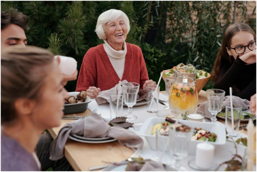 Smiling elderly woman with family and friends enjo
