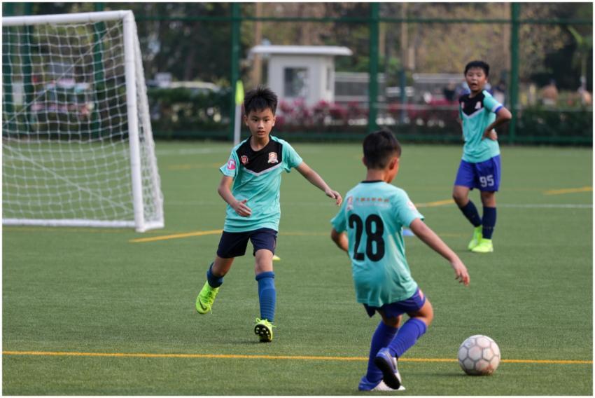 Boys playing youth soccer on a sunny day, wearing