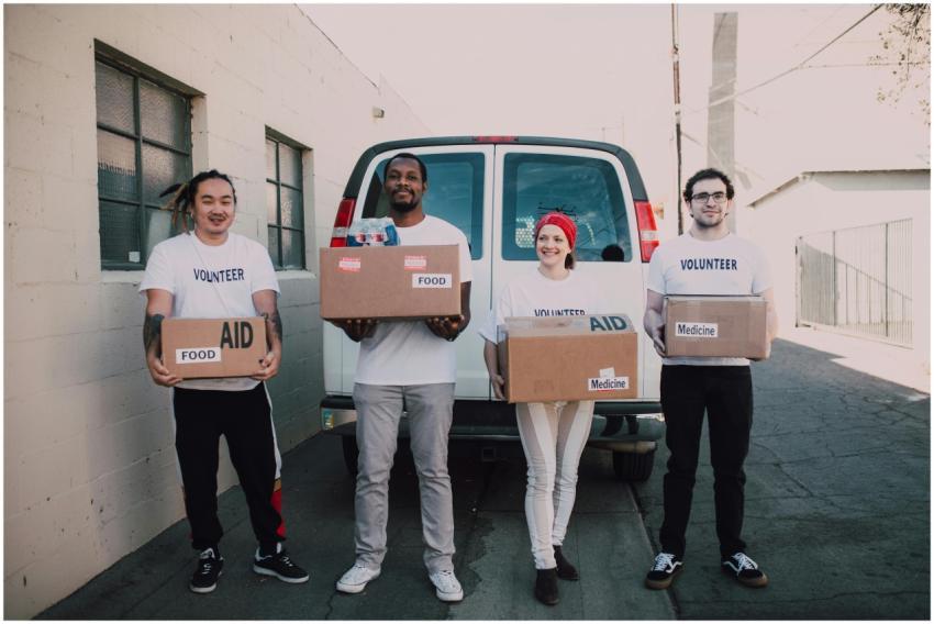 Group of volunteers holding aid boxes, ready to di