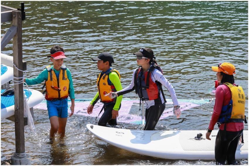 Children and instructor learning windsurfing by th