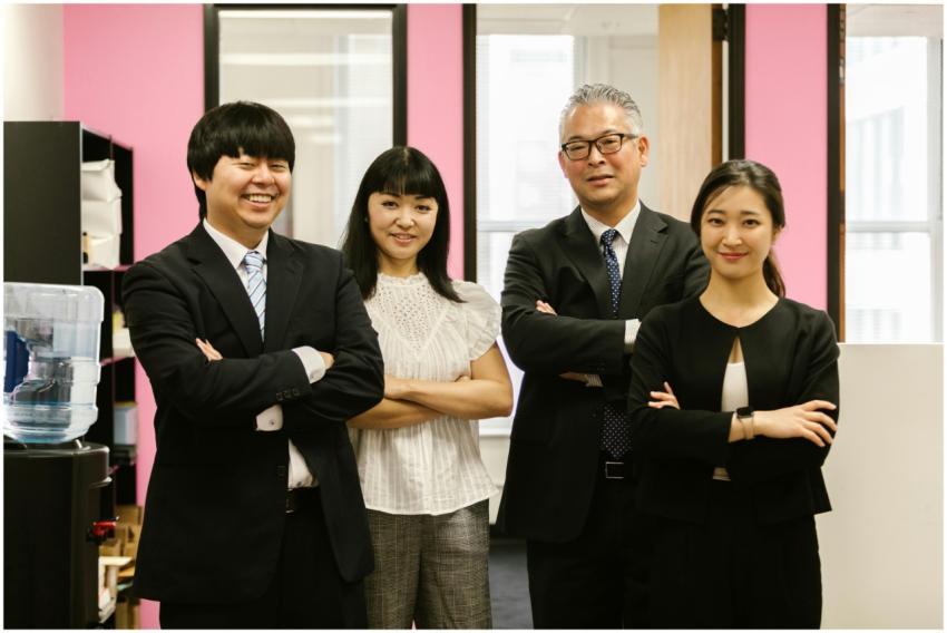 Four business professionals standing with confiden