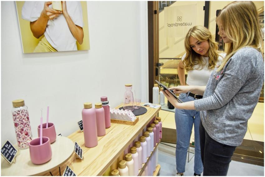 Two women exploring sustainable water bottles in a