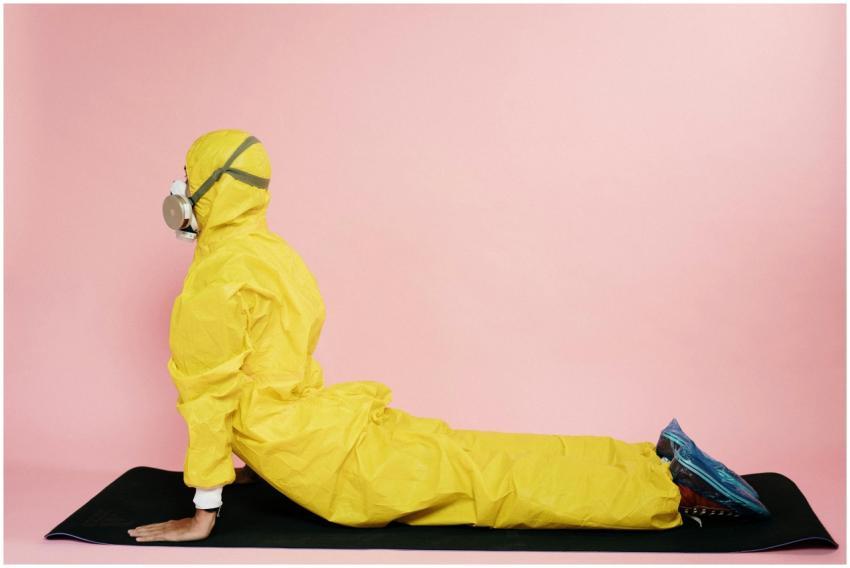 Individual in yellow protective suit and mask doin