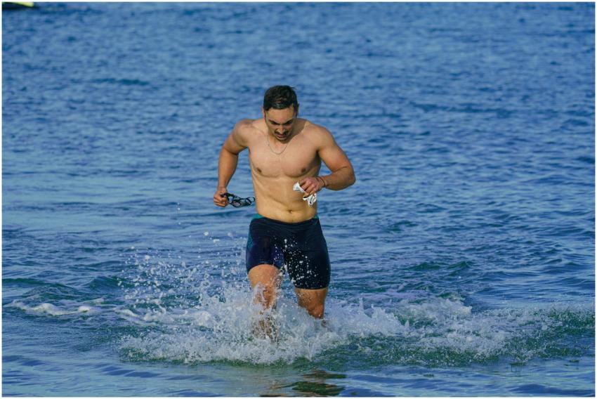 A fit man running out of the sea at Kuşadası beach