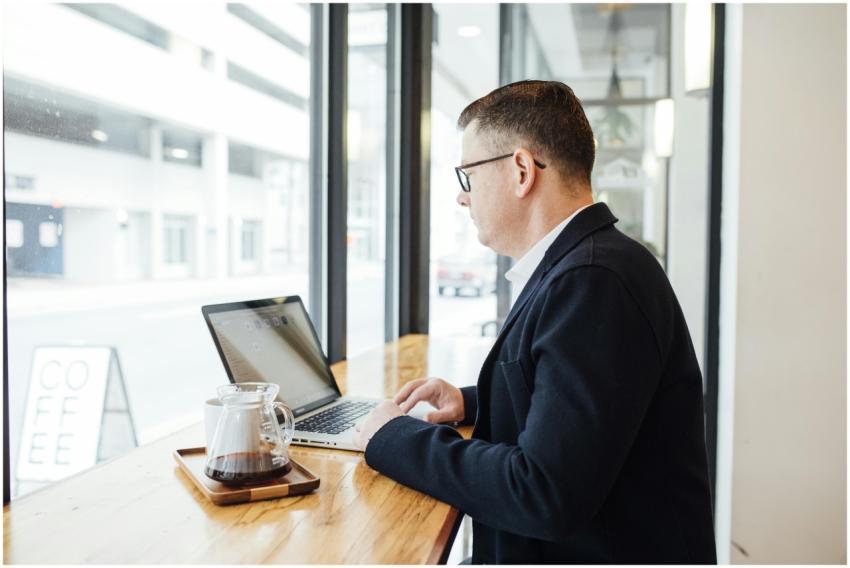 Businessman in a cafe working on a laptop with cof