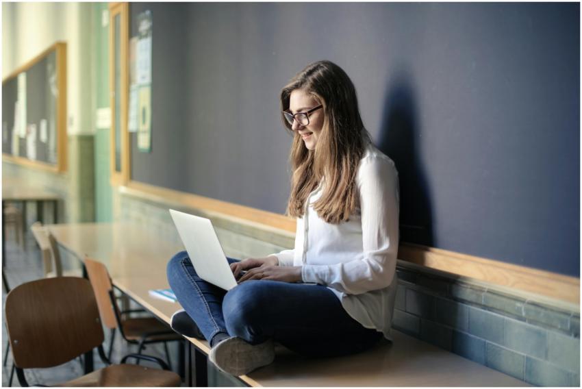 Focused student using laptop in an empty classroom
