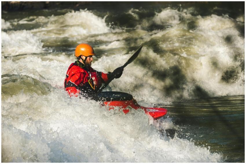 Man kayaking through whitewater rapids, showcasing