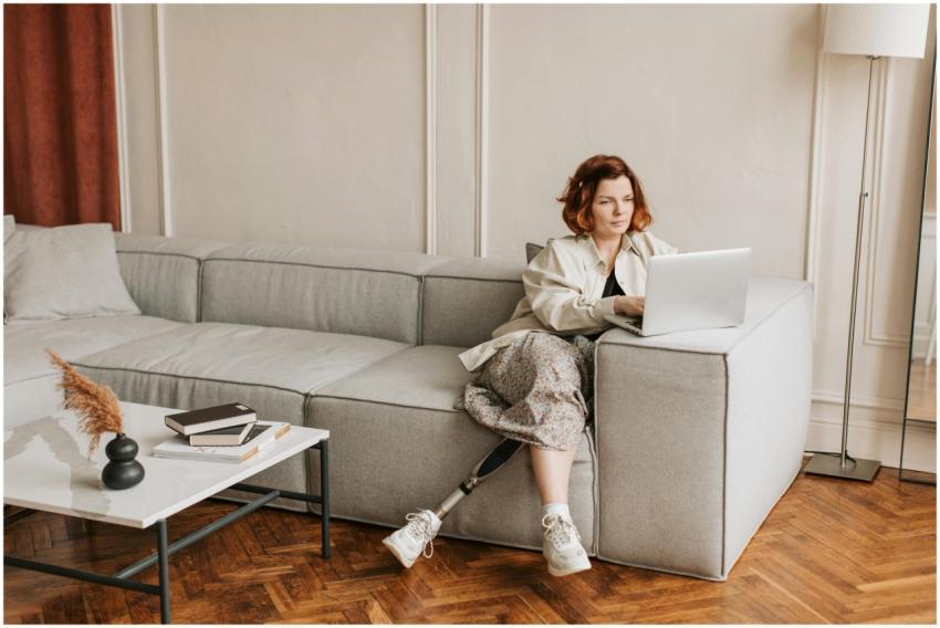 A woman with a prosthetic leg works remotely on a