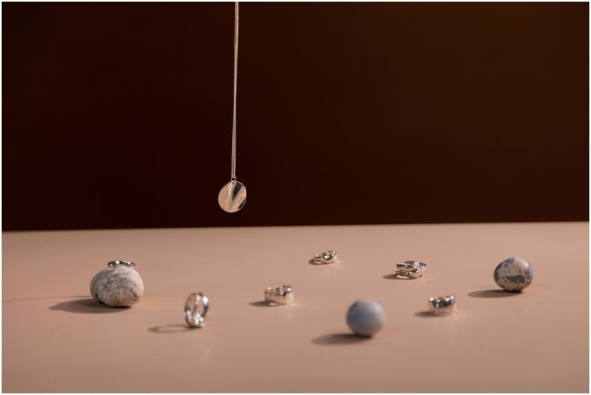 Elegant still life featuring silver jewelry with g