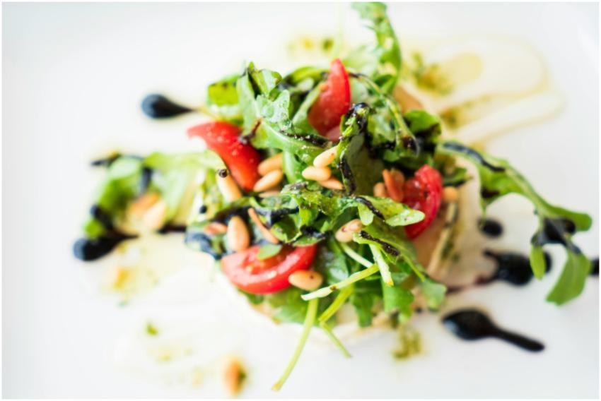 A vibrant arugula salad with cherry tomatoes, pine