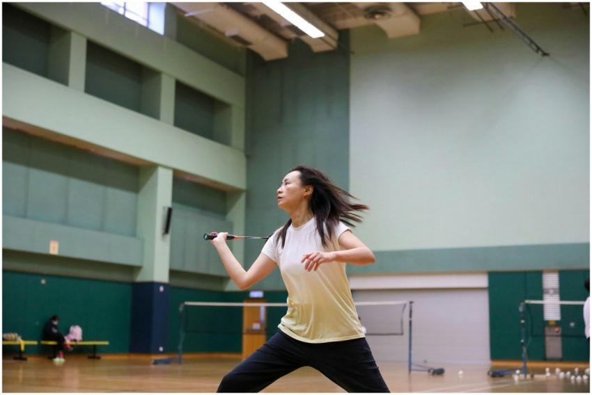 Dynamic action shot of a woman playing badminton i