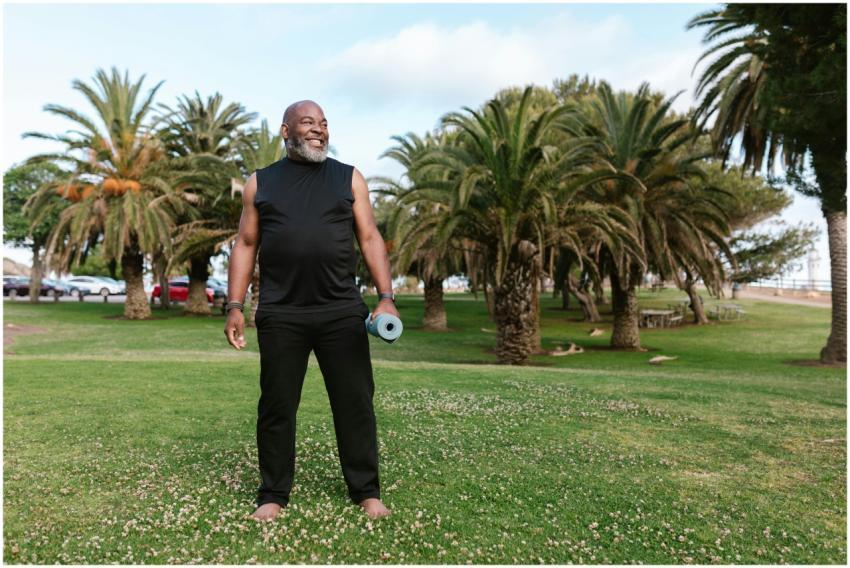 Elderly African American man doing yoga with a mat