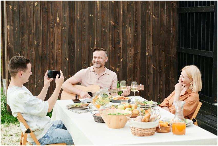 A family enjoying a meal outdoors with music and l