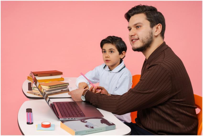 Male teacher and young boy studying together at a