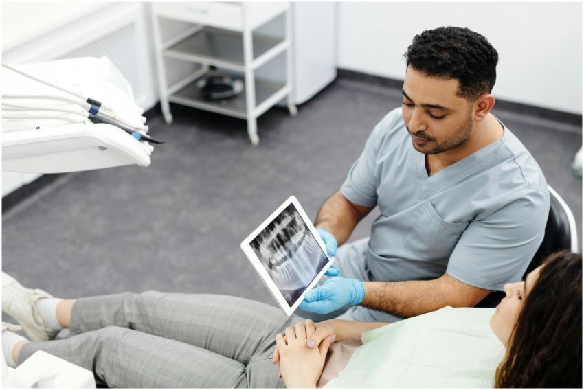 Dentist showing dental x-ray on tablet to a patien