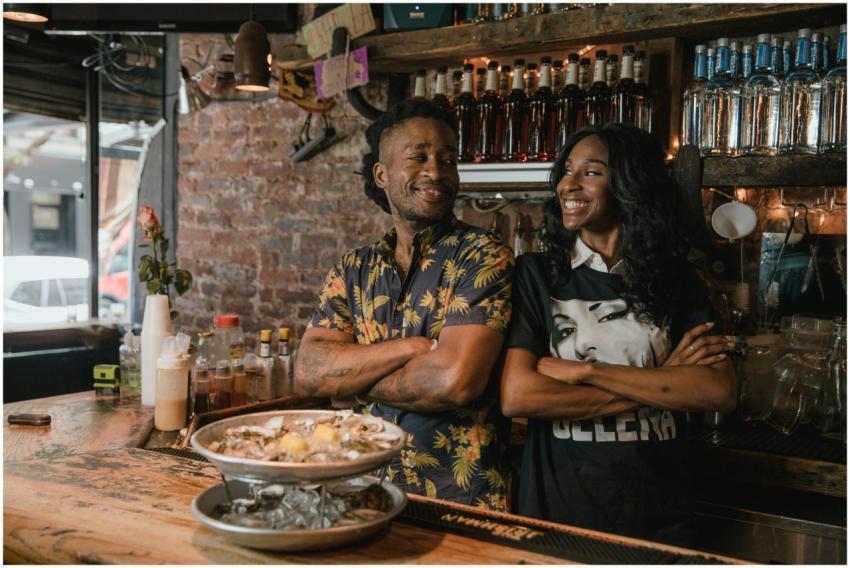 Two Black business owners smiling confidently behi