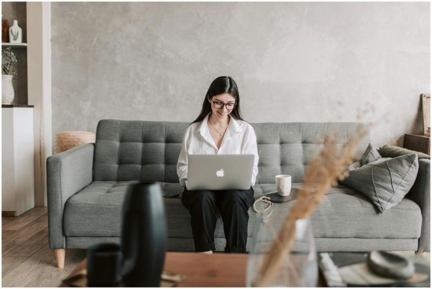A woman works remotely on a laptop while sitting c