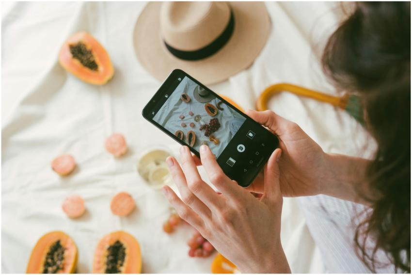 A person uses a smartphone to photograph an artist