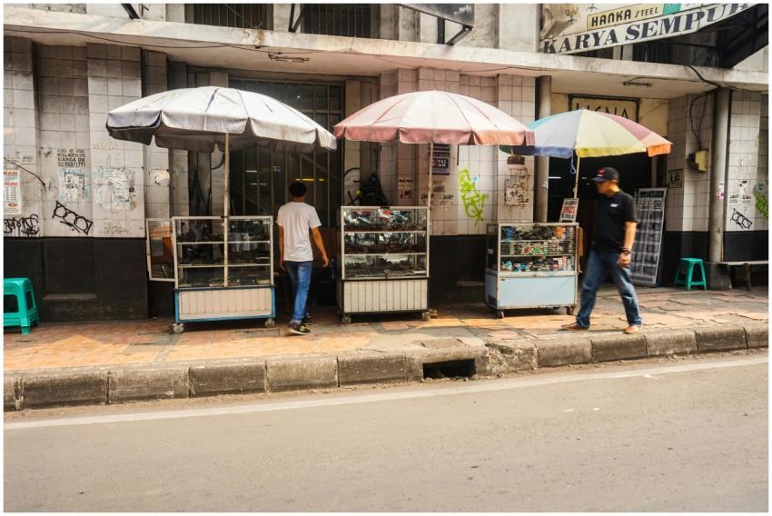 Outdoor street vendor stalls with umbrellas and wa