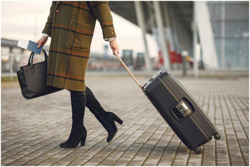A fashionable woman in a coat walks with luggage a