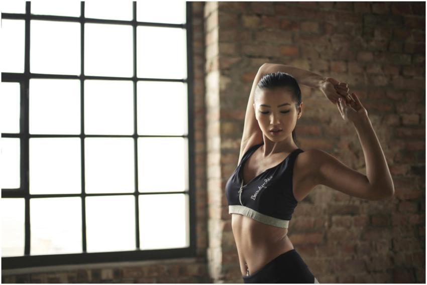 A woman practicing yoga indoors, highlighting stre