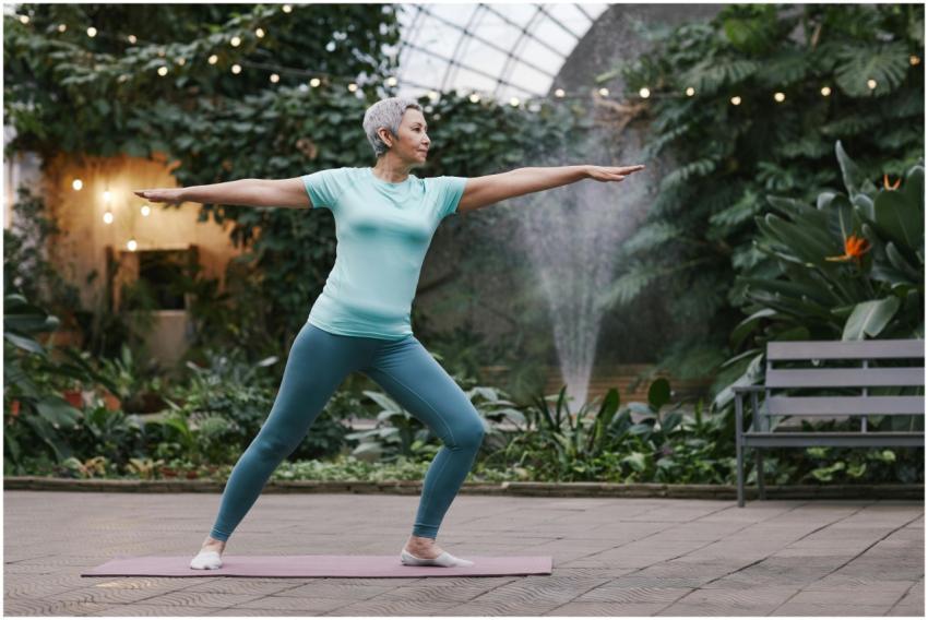 Serene senior woman in warrior pose doing yoga in
