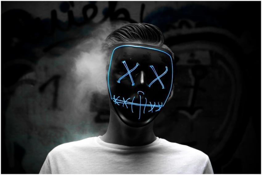 Dark portrait of a person wearing a glowing LED ma