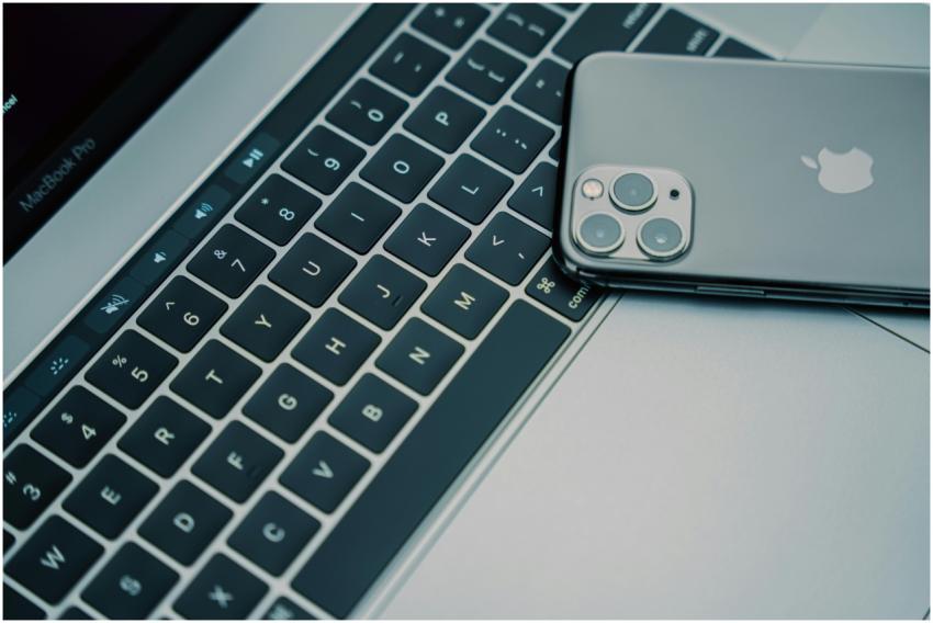 A close-up of a MacBook Pro keyboard and an iPhone