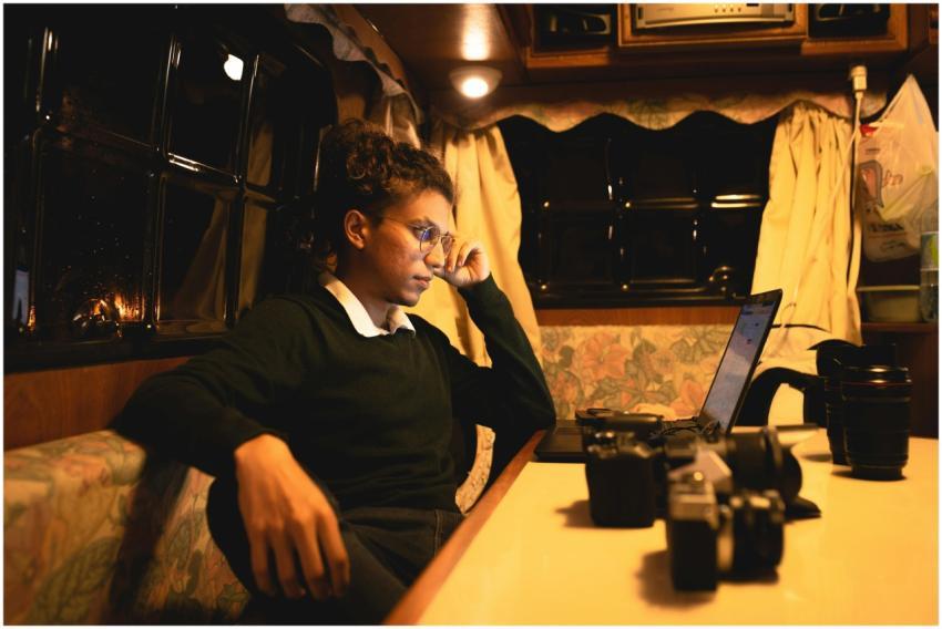 A person working on a laptop in a cozy room with w