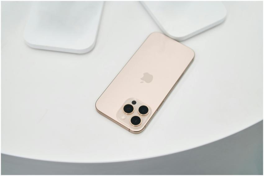 Golden smartphone with triple camera on a clean wh