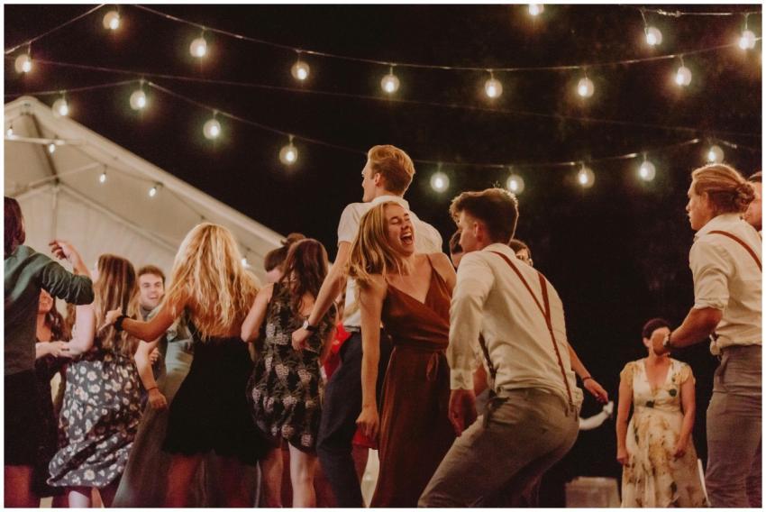 A lively outdoor night party with people dancing u