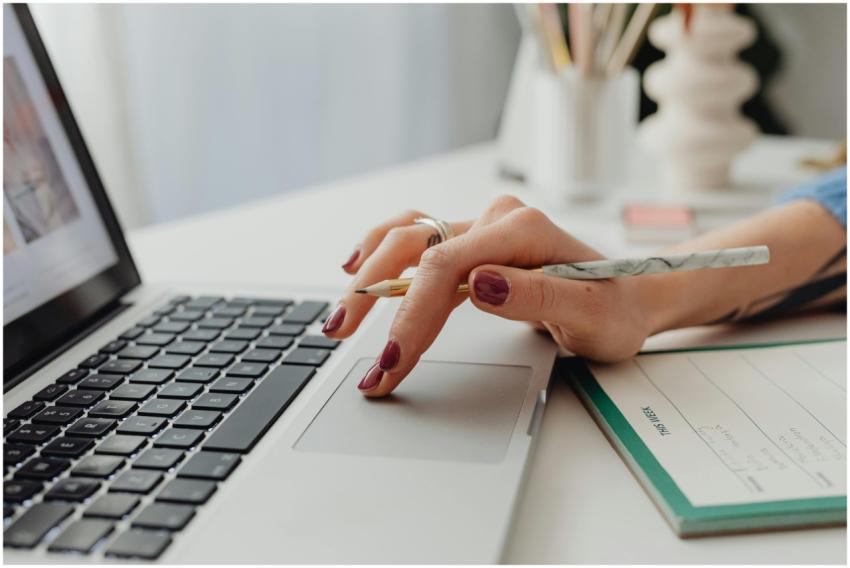 A close-up shot of a woman's hand on a laptop touc