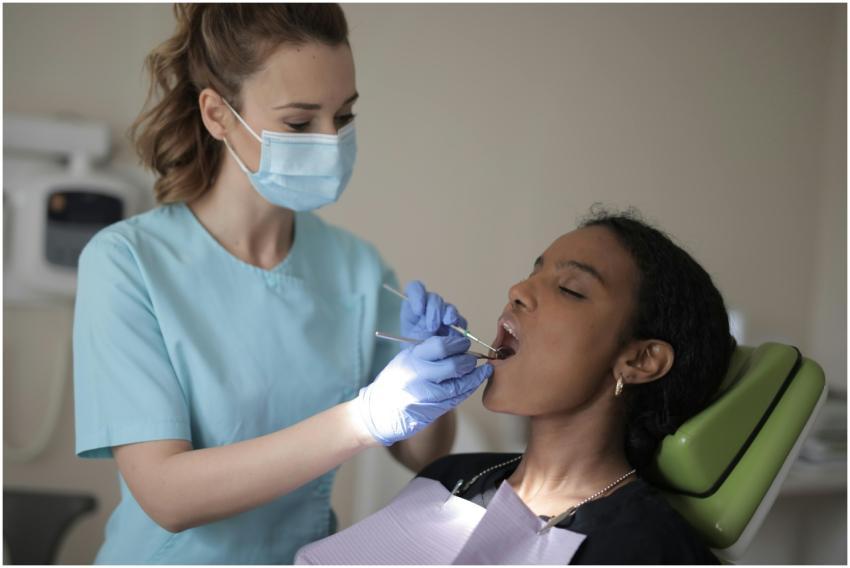 Side view of young female dentist in mask and glov