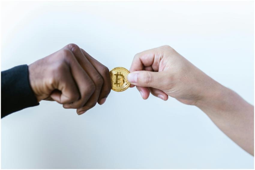 Two hands exchanging a Bitcoin coin, symbolizing c