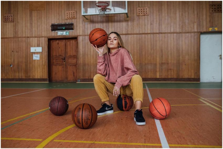 Stylish woman posing confidently with basketballs