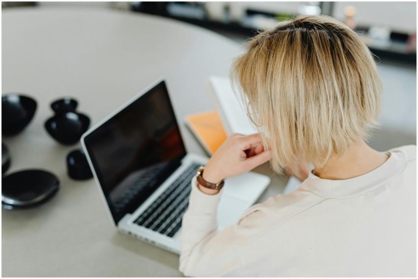 A woman with short blond hair working on a laptop