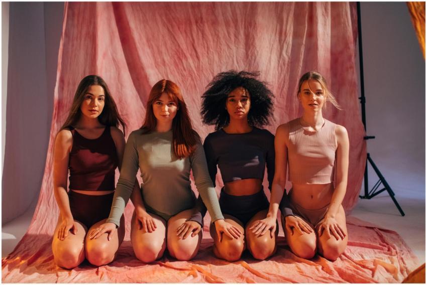 Four diverse women in activewear posing together i