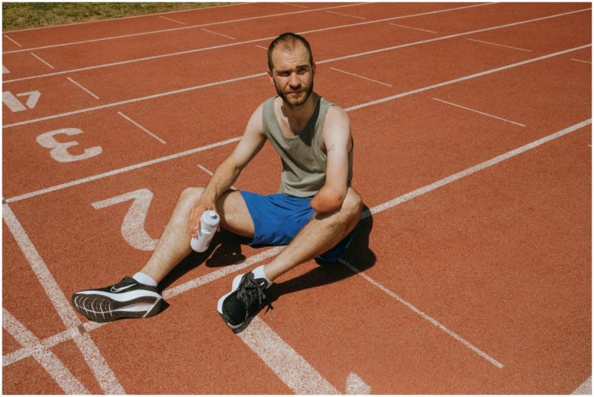 Athlete taking a break on a running track with a w